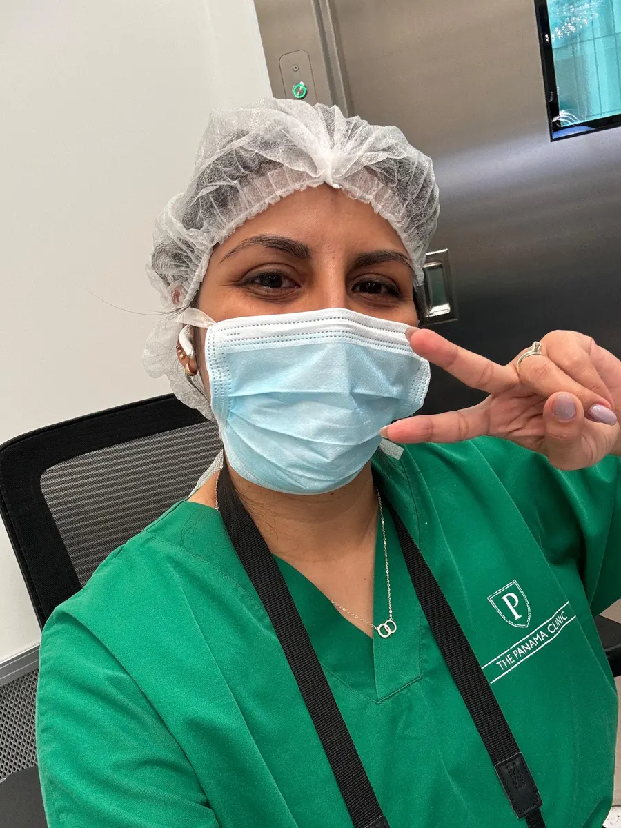 Team member in cap and mask, wearing The Panama Clinic scrubs