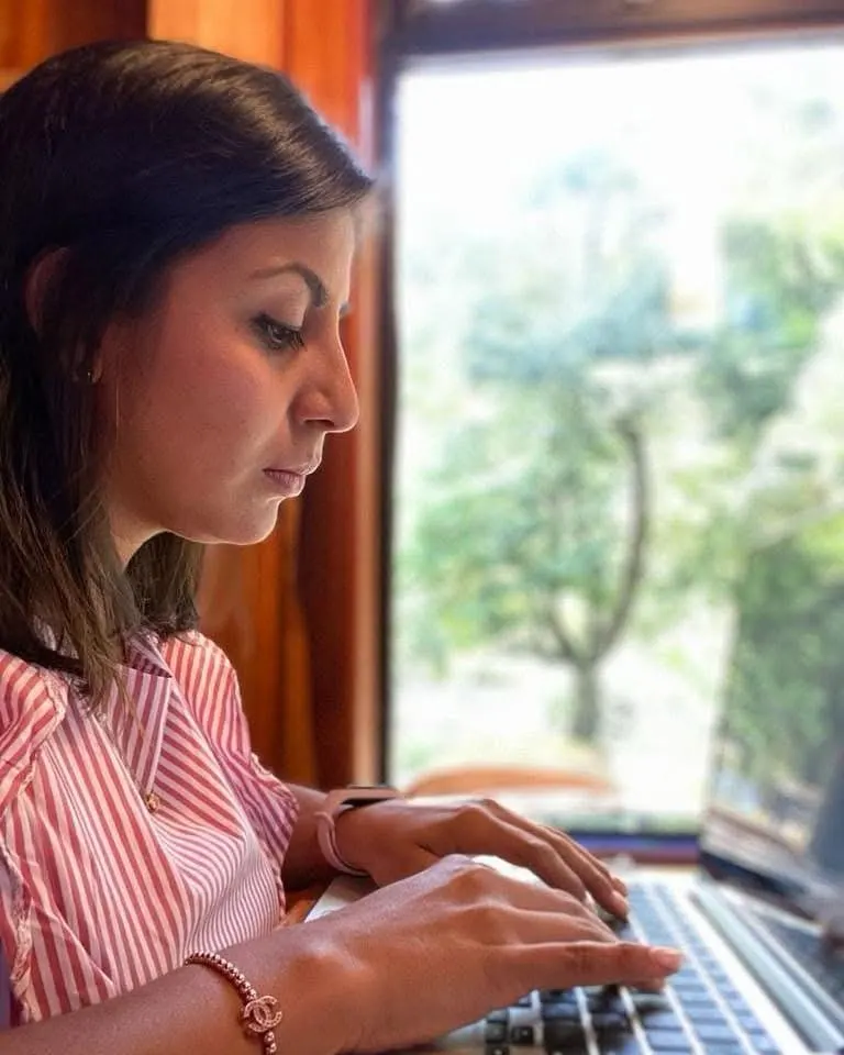 Nayita partner working on her laptop by a window
